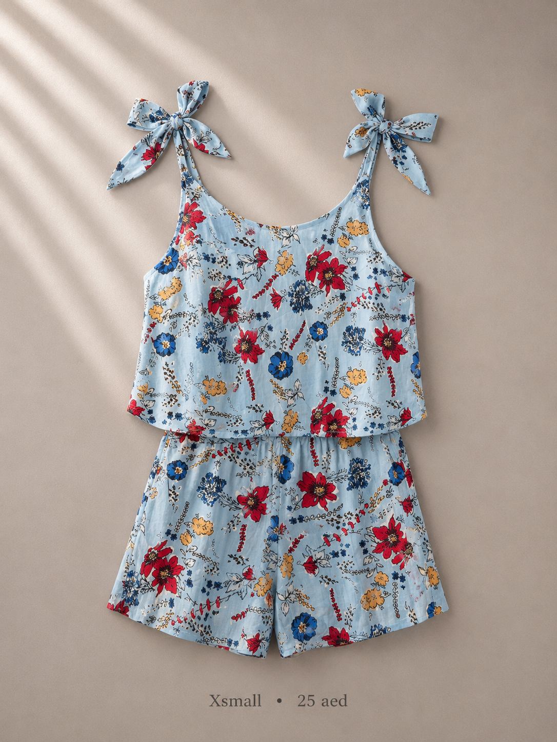 Powder blue ditsy floral cami romper with knotted bow straps, size XSmall